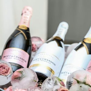 Elegant display of Moet & Chandon champagne in an ice bucket adorned with roses, perfect for celebrations.